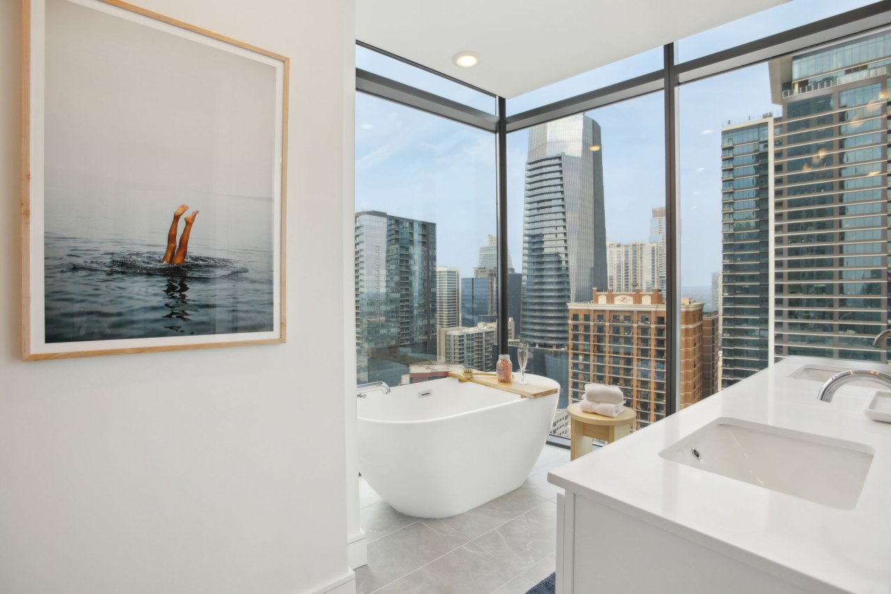 87-web-or-mls-colorado st model 2312 b1-024 a bathroom with floor to ceiling windows, white stone counters and marble floors, and a free-standing tub